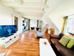 a living room with a couch and a flat screen tv at Ginsterweg 1a in Wyk auf Föhr