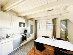a kitchen with white cabinets and a table with chairs at Ginsterweg 1a in Wyk auf Föhr