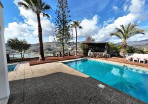 a swimming pool with palm trees and a house at Great property - amazing views in Limassol