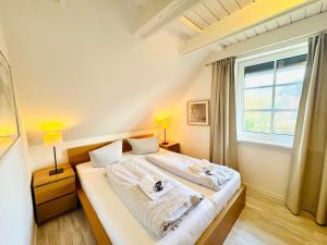 a bedroom with a bed with two towels on it at Ginsterweg 1a in Wyk auf Föhr +9 photos