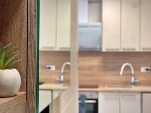 a kitchen with white cabinets and stainless steel appliances at Apartments Bonum in Šilo +70 photos