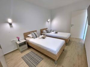 two beds in a small room with white walls at Apartments Bonum in Šilo