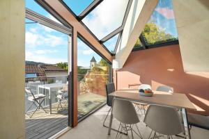 a room with a balcony with a table and chairs at Bryggen Penthouse I NEW 2021 in Bergen