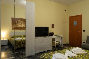 a bedroom with a bed and a desk with a television at CameraCafè in Ferrara