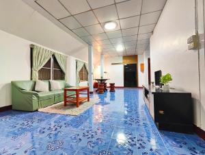 ein Wohnzimmer mit einem blauen und weißen Fliesenboden in der Unterkunft Sansai Home - 2 Bedrooms 2 Bathrooms in Ban San Pu Loei