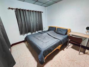 Schlafzimmer mit einem Bett mit einem Tisch und einem Fenster in der Unterkunft Sansai Home - 2 Bedrooms 2 Bathrooms in Ban San Pu Loei