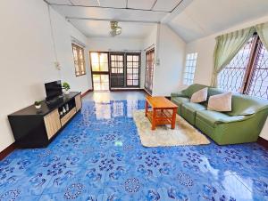 ein Wohnzimmer mit einer grünen Couch und einem Tisch in der Unterkunft Sansai Home - 2 Bedrooms 2 Bathrooms in Ban San Pu Loei