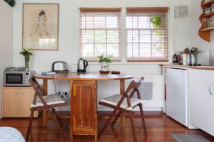 a kitchen with a table and chairs in a kitchen at Self contained garden studio in London