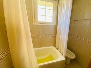 ein Badezimmer mit Badewanne und Toilette und einem Fenster in der Unterkunft Canales de Veneciola by Alina365 in La Manga del Mar Menor + 33 Fotos