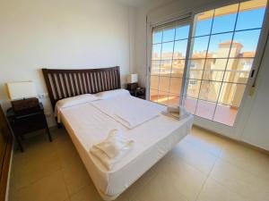 ein Schlafzimmer mit einem Bett und einem großen Fenster in der Unterkunft Canales de Veneciola by Alina365 in La Manga del Mar Menor
