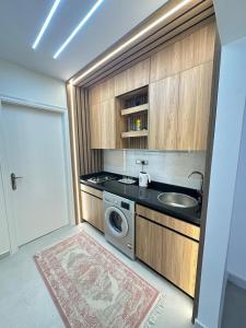 a small kitchen with a sink and a washing machine at Bisan Apartment in Madinat Al Ashir min Ramadan