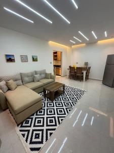 a living room with a couch and a table at Bisan Apartment in Madinat Al Ashir min Ramadan