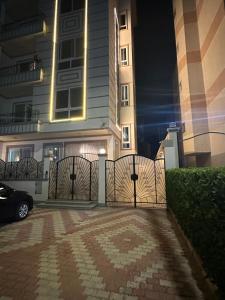 a gate in front of a building at night at Bisan Apartment in Madinat Al Ashir min Ramadan