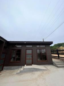 a small building with a red door and windows at Cabañas Piedrablanca in Bucalemu
