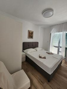a bedroom with a bed and a chair in it at Apartments Nada in Sućuraj