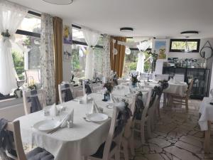 a dining room with white tables and chairs and windows at Max in Żukowo