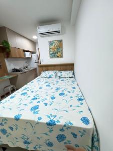 a bedroom with a bed with blue flowers on it at Smart Convenções in Salvador
