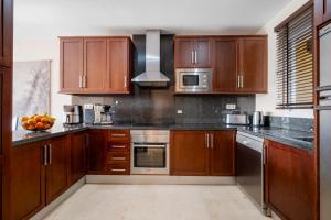 a kitchen with wooden cabinets and stainless steel appliances at Penthouse with Jacuzzi by Costarentals - Ref 244 in Fuengirola