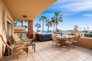 a patio with a table and chairs and a hot tub at Penthouse with Jacuzzi by Costarentals - Ref 244 in Fuengirola +23 photos