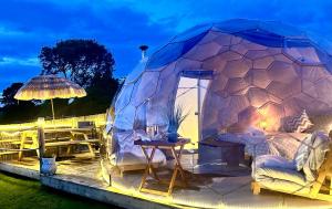 a bed in a dome tent with a table at Deerstone Glamping-Weets Hill dome with Hot tub in Earby