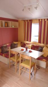 a living room with a table and a couch at Camping Sable d'Or 3 chambres in Cap d'Agde