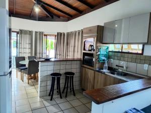 a kitchen with a counter and stools in it at Pousada Recanto das Palmeiras in Florianópolis