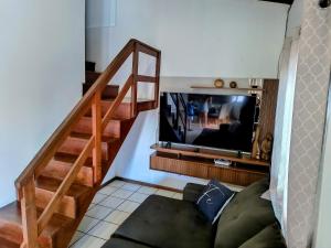 a living room with a couch and a television at Pousada Recanto das Palmeiras in Florianópolis