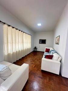 a living room with two white couches and a television at Casa Bela Vista in São Lourenço