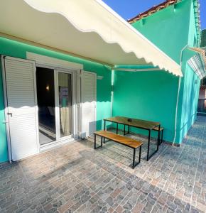 a wooden bench sitting outside of a blue building at Magellanos Mint House- Kinopiastes in Kynopiástai +23 photos