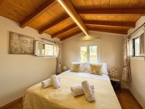 a bedroom with a bed with two towels on it at Vilia Port House- Corfu Centre in Mantoúkion