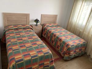 two beds sitting next to each other in a room at Casa Conricado in O Grove