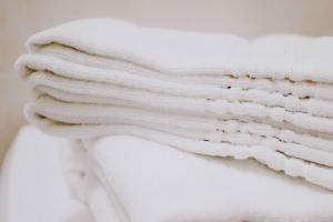 a stack of white towels sitting on top of a toilet at Residence Rose di Fratta in Cupramontana +40 photos