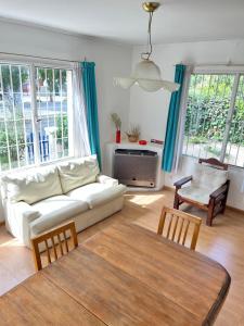 a living room with a white couch and a table at Casa Bóscaro in Comodoro Rivadavia