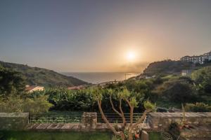 a view of the sunset from the garden at João Loft I by Mth in Campanário