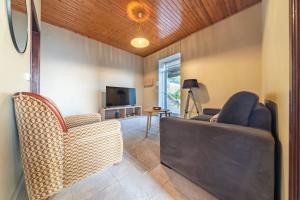 a living room with a couch and chairs and a television at João Loft I by Mth in Campanário