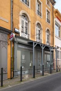 ein Geschäft vor einem Gebäude auf einer Straße in der Unterkunft Parenthèse Occitane - Free Parking - Balnéothérapie in Carcassonne