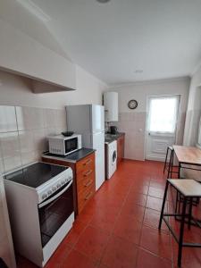 a kitchen with a stove and a microwave in it at Haus Am Grünen Meer in Angra do Heroísmo +15 photos