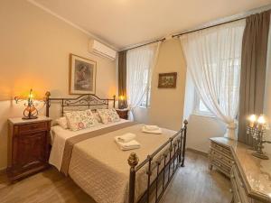 a bedroom with a bed with two towels on it at Dion and Eva's OldTown Apartment in Corfu Town