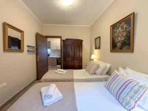 a bedroom with two beds with white sheets at Dion and Eva's OldTown Apartment in Corfu Town