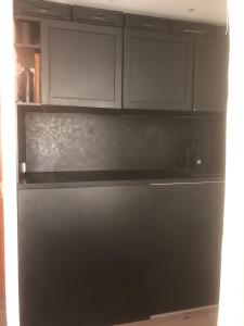 a black kitchen with white cabinets and a sink at Cozy 1 room apartment for 2 in Munich +9 photos