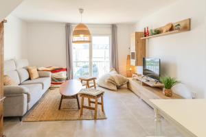 a living room with a couch and a tv at Tarifa Cozy House - Casita Central in Tarifa +18 photos