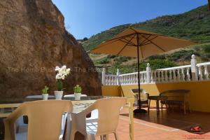 a patio with a table and an umbrella at Casa La Cabaña in Gáldar