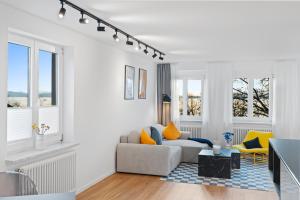 un soggiorno bianco con divano e sedie gialle di Anytime - Ferienwohnungen am Uferpark direkt am See a Friedrichshafen Altre 65 foto