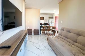 a living room with a couch and a kitchen at Bessa Apto Novinho 200m Praia 2 Quartos 5 Pessoas in Nossa Senhora do Livramento