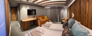 a living room with a couch and a television at Hotel La Baita in Folgaria