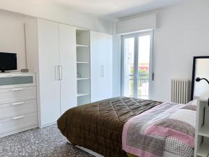 a white bedroom with a bed and a television at Isabel apulian apartment in Molfetta