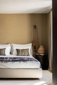 een slaapkamer met een bed met kussens erop bij Le Mas des Baux in Les Baux-de-Provence