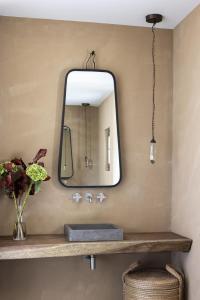 een badkamer met een spiegel en een wastafel bij Le Mas des Baux in Les Baux-de-Provence