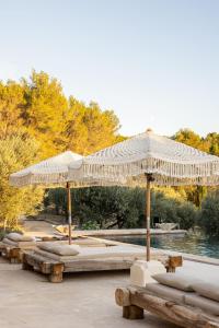 een rij banken met parasols in een park bij Le Mas des Baux in Les Baux-de-Provence +18 foto's