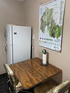 ein Tisch mit Kühlschrank und einer Karte an der Wand in der Unterkunft Departamento Pleno Centro Amplio y Cómodo in San Salvador de Jujuy